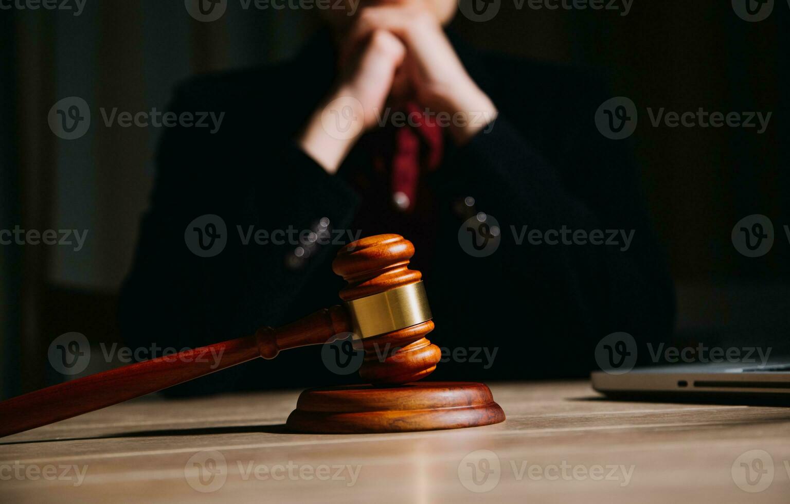 Justice and law concept.Male judge in a courtroom with the gavel, working with, computer and docking keyboard, eyeglasses, on table in morning light photo
