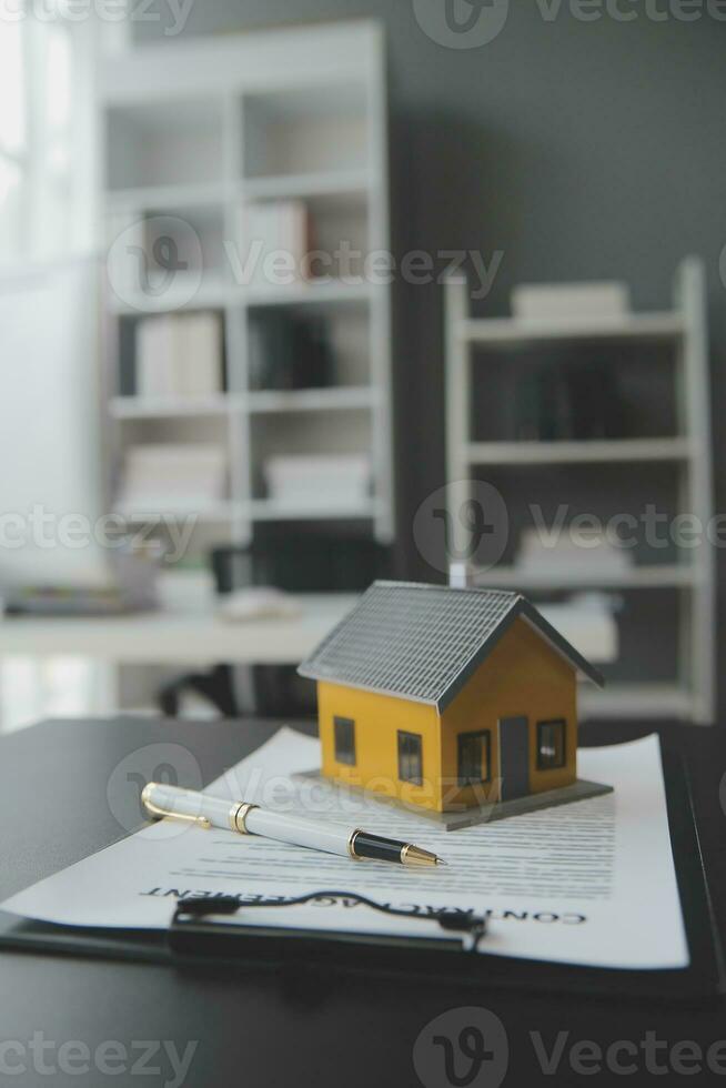 House model with real estate agent and customer discussing for contract to buy house, insurance or loan real estate background. photo