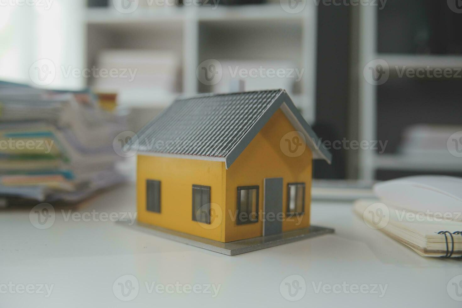 House model with real estate agent and customer discussing for contract to buy house, insurance or loan real estate background. photo
