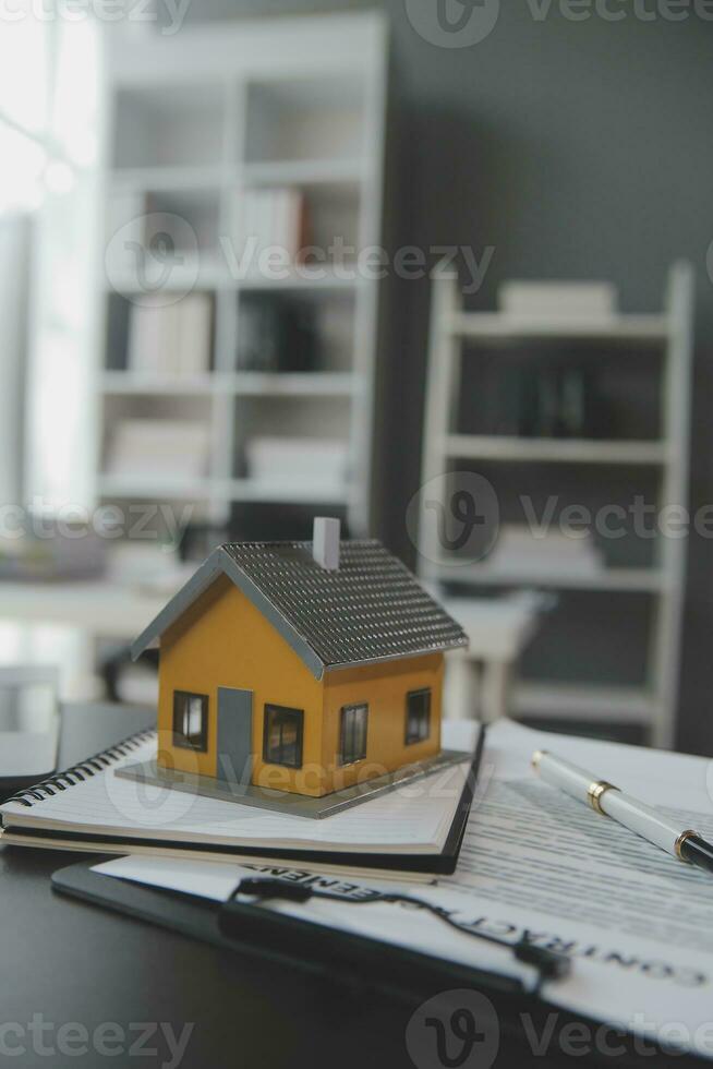 House model with real estate agent and customer discussing for contract to buy house, insurance or loan real estate background. photo