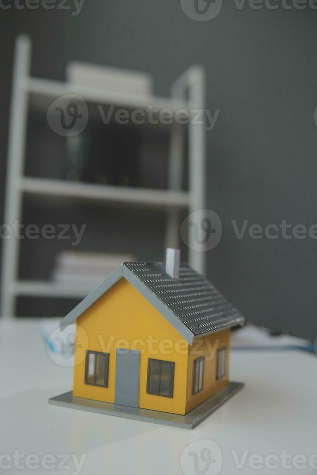 House model with real estate agent and customer discussing for contract to buy house, insurance or loan real estate background. photo