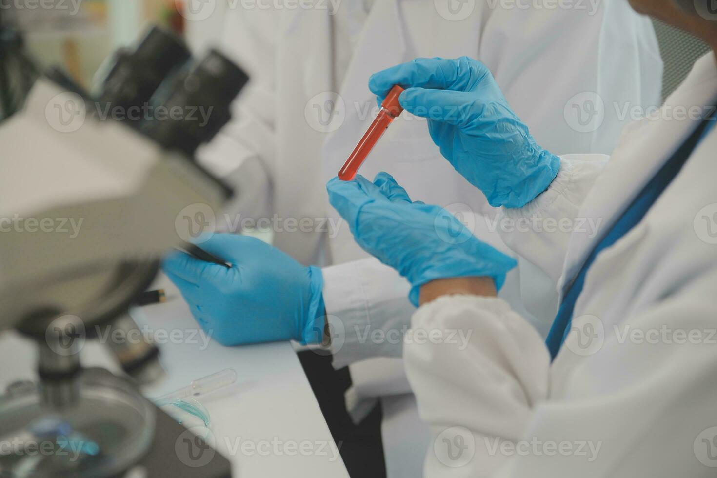 Health care researchers working in life science laboratory. Young female research scientist and senior male supervisor preparing and analyzing microscope slides in research lab. photo