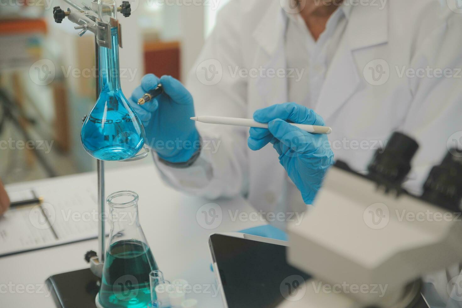 Health care researchers working in life science laboratory. Young female research scientist and senior male supervisor preparing and analyzing microscope slides in research lab. photo