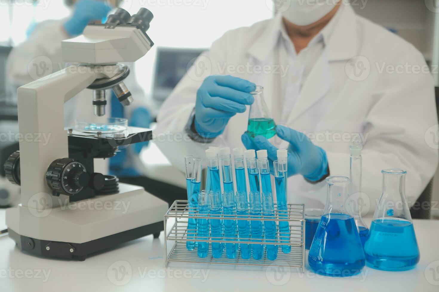 Health care researchers working in life science laboratory. Young female research scientist and senior male supervisor preparing and analyzing microscope slides in research lab. photo