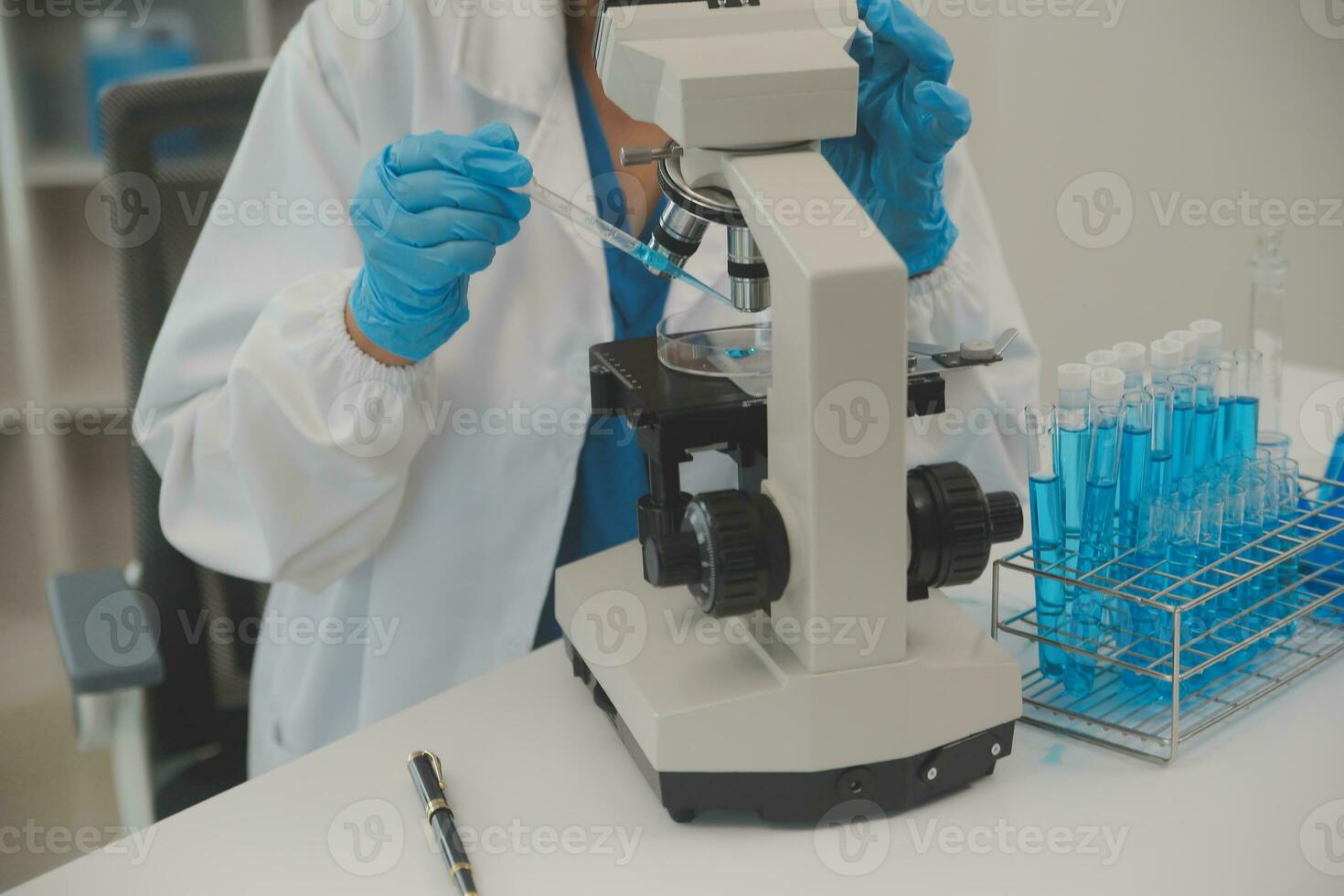 Health care researchers working in life science laboratory. Young female research scientist and senior male supervisor preparing and analyzing microscope slides in research lab. photo