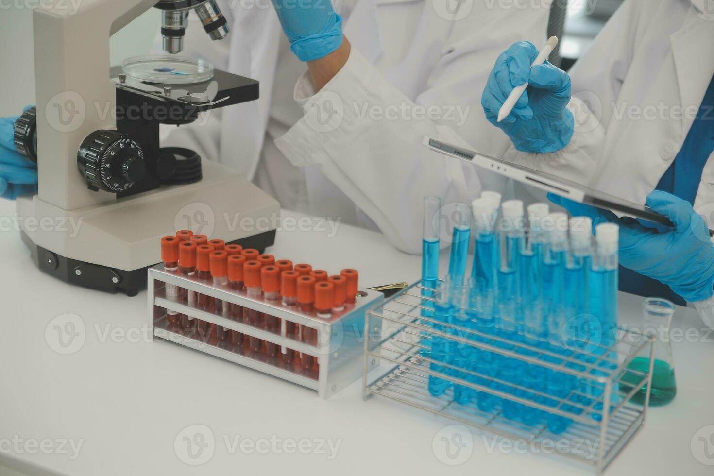 Health care researchers working in life science laboratory. Young female research scientist and senior male supervisor preparing and analyzing microscope slides in research lab. photo