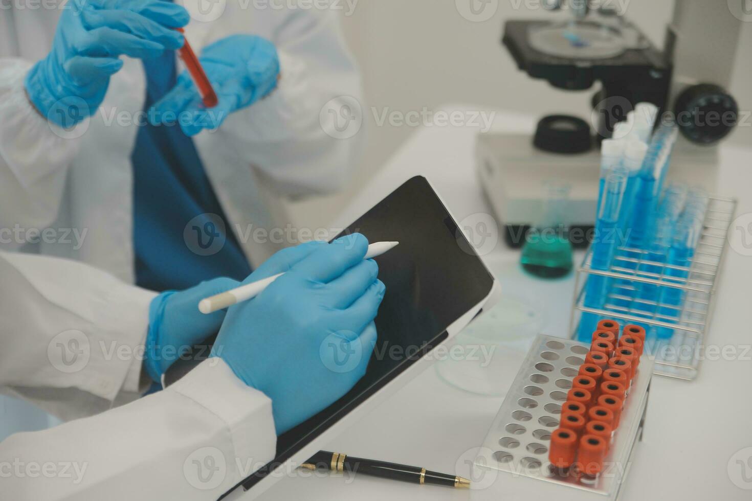 Health care researchers working in life science laboratory. Young female research scientist and senior male supervisor preparing and analyzing microscope slides in research lab. photo