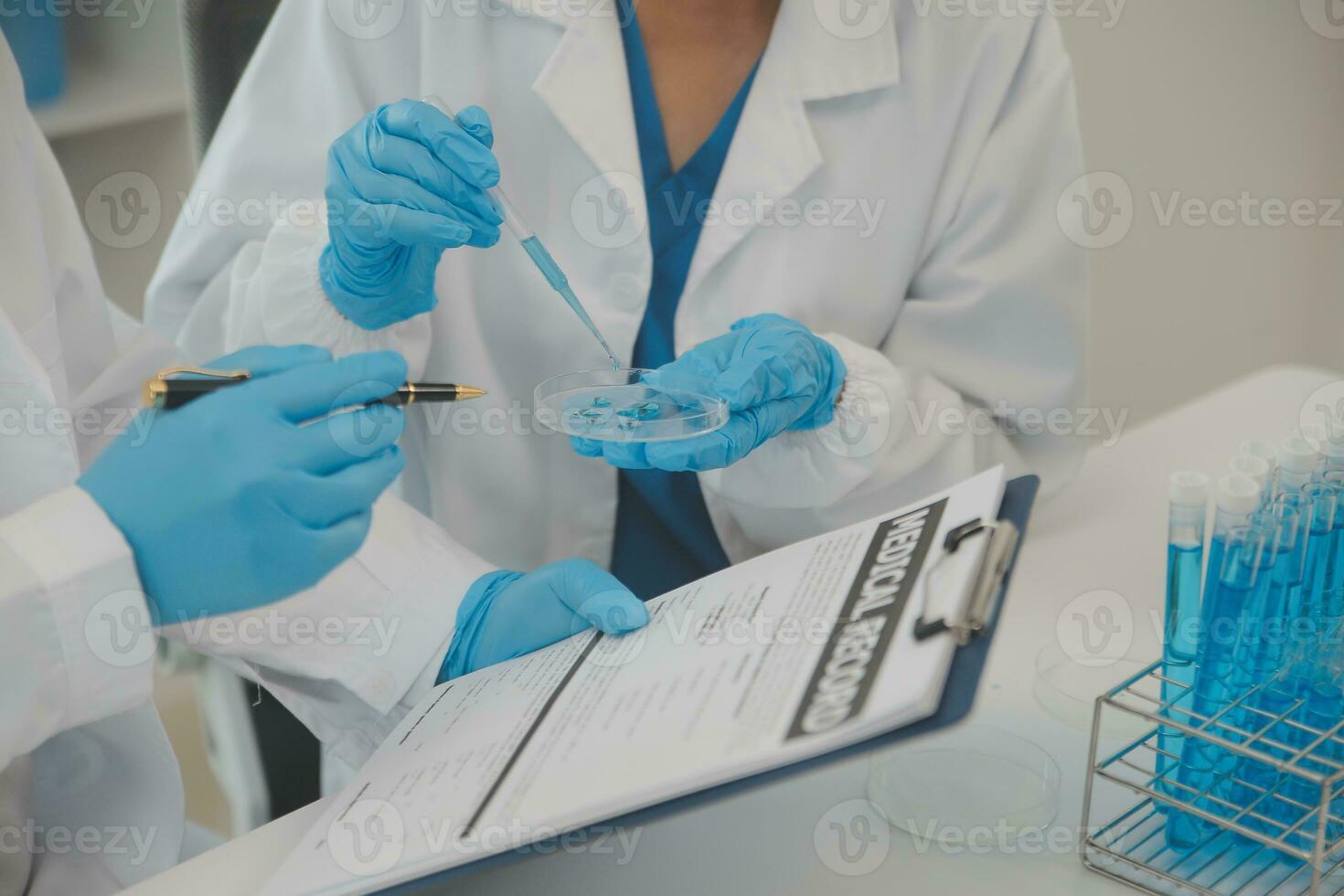 Health care researchers working in life science laboratory. Young female research scientist and senior male supervisor preparing and analyzing microscope slides in research lab. photo