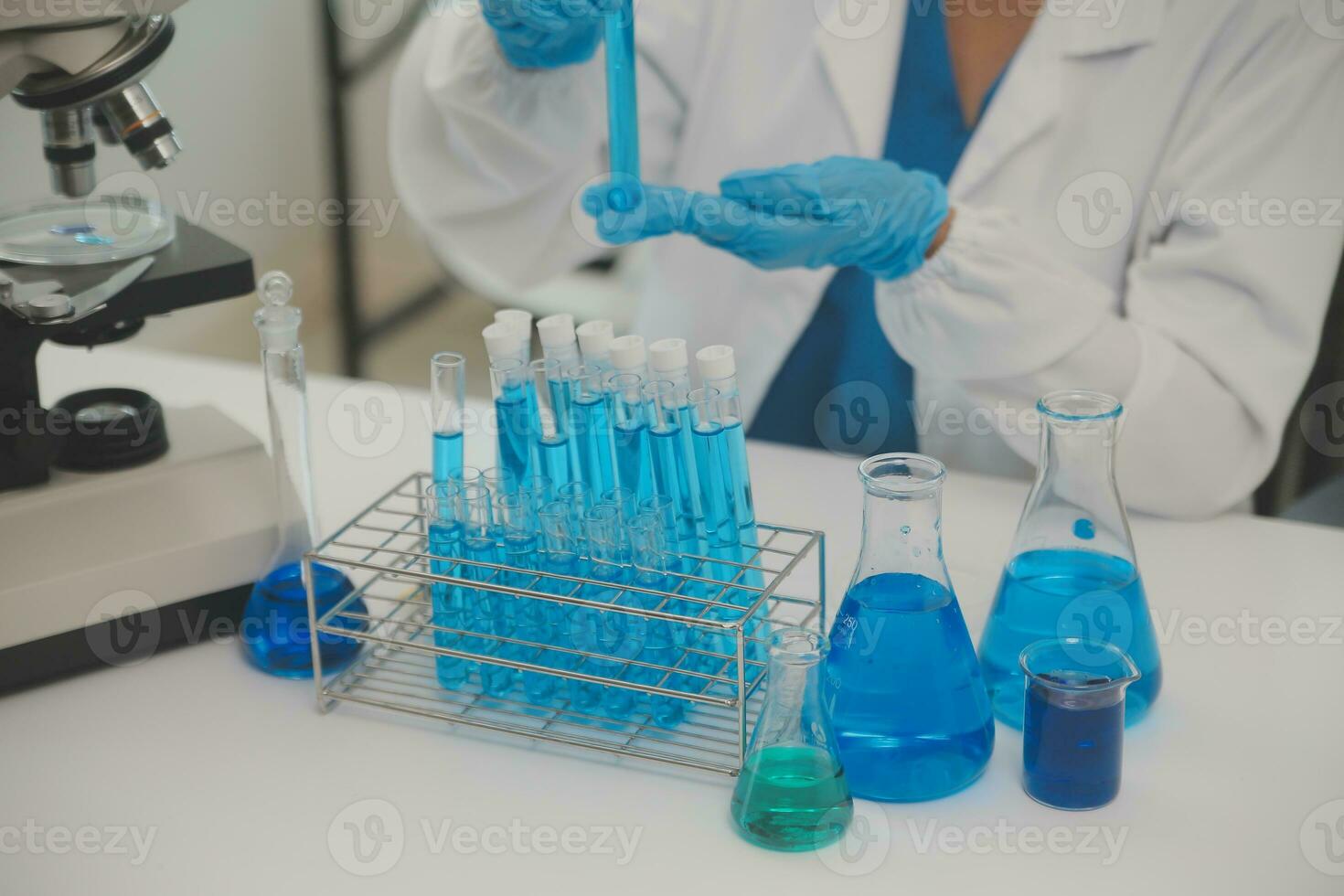 Health care researchers working in life science laboratory. Young female research scientist and senior male supervisor preparing and analyzing microscope slides in research lab. photo