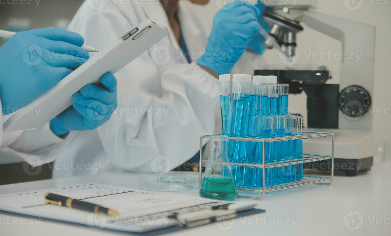 Health care researchers working in life science laboratory. Young female research scientist and senior male supervisor preparing and analyzing microscope slides in research lab. photo