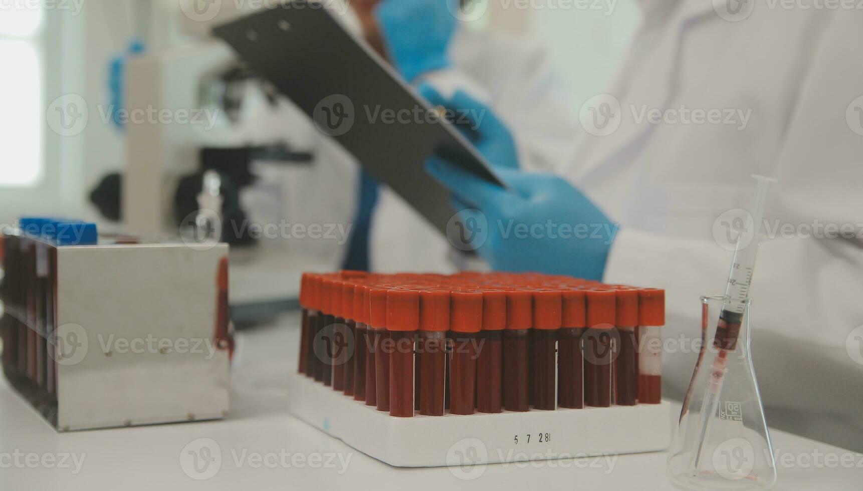 Health care researchers working in life science laboratory. Young female research scientist and senior male supervisor preparing and analyzing microscope slides in research lab. photo