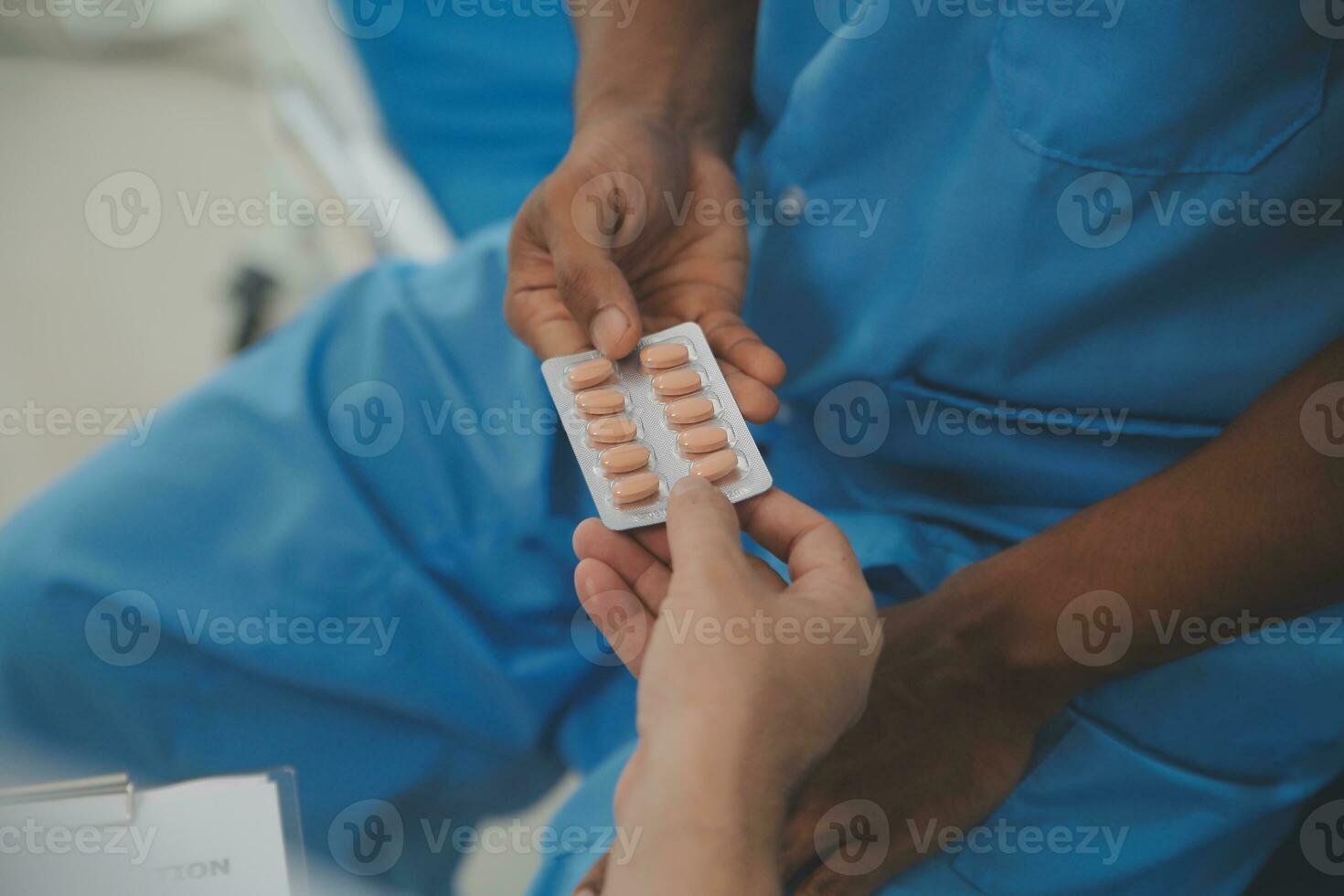 Close up of doctor sitting on bedside of male patient in hospital photo