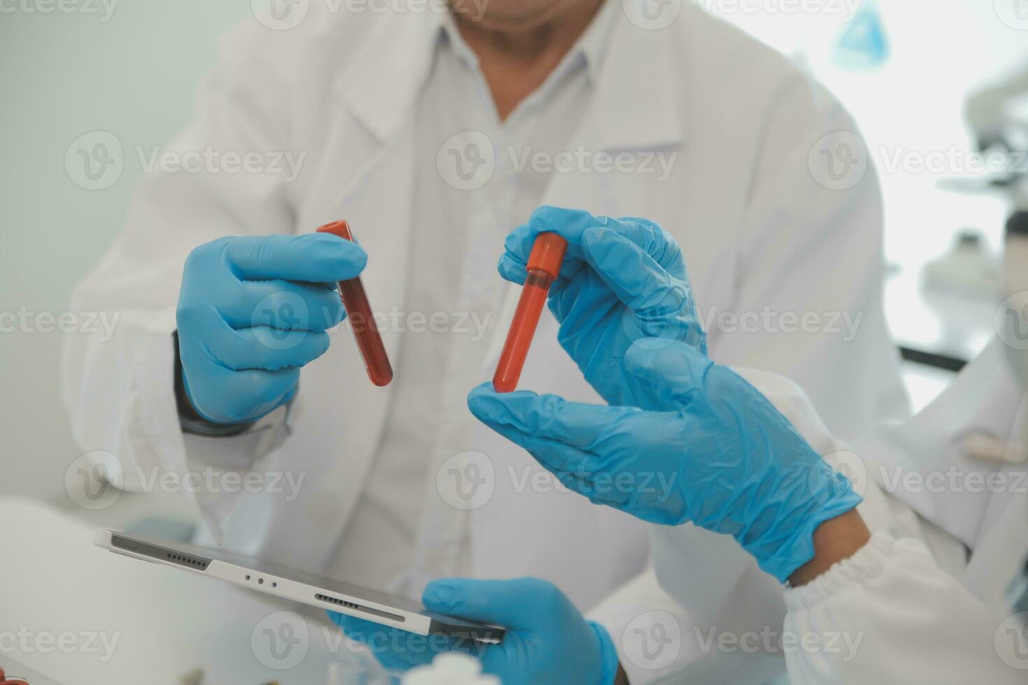 Health care researchers working in life science laboratory. Young female research scientist and senior male supervisor preparing and analyzing microscope slides in research lab. photo