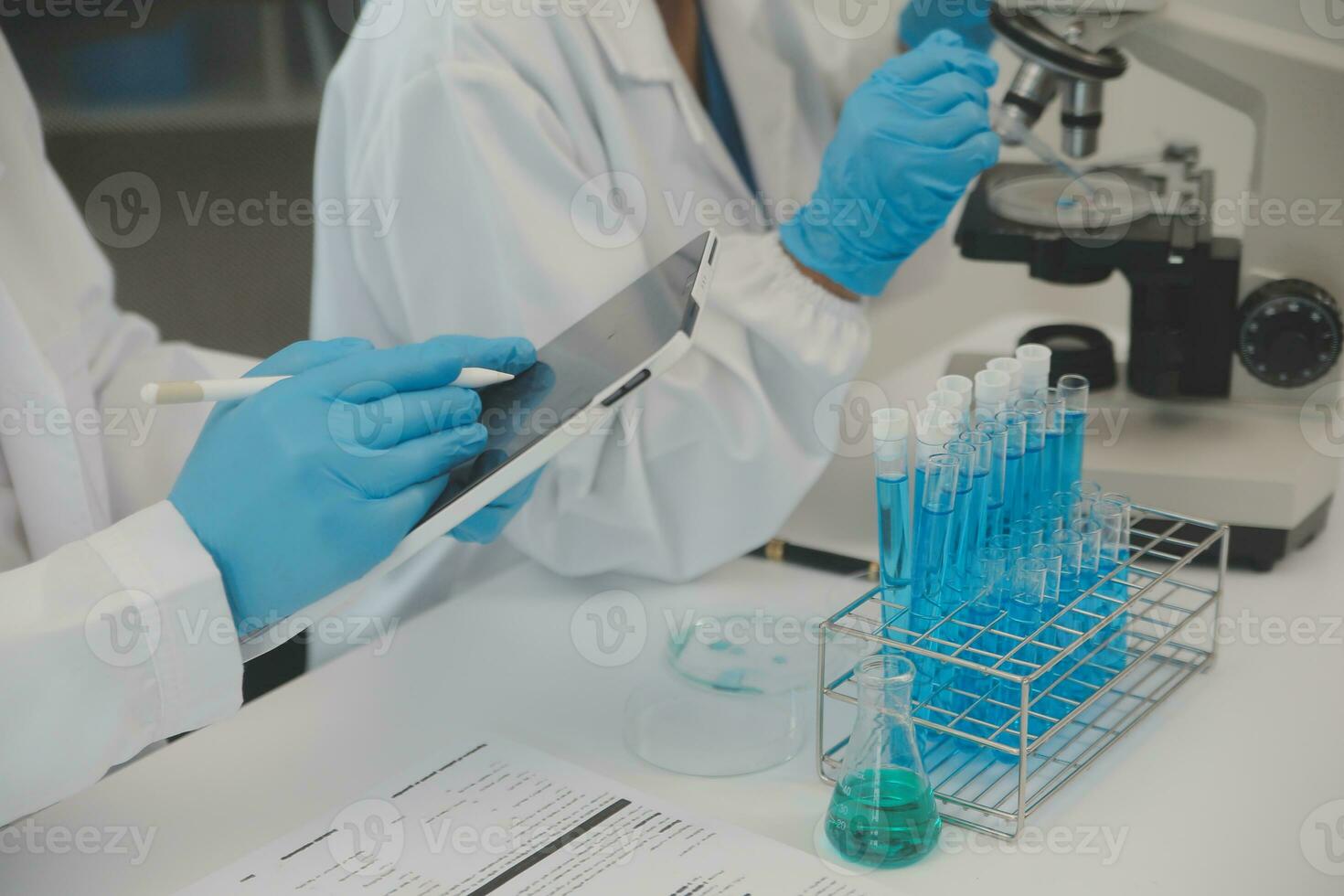 Health care researchers working in life science laboratory. Young female research scientist and senior male supervisor preparing and analyzing microscope slides in research lab. photo