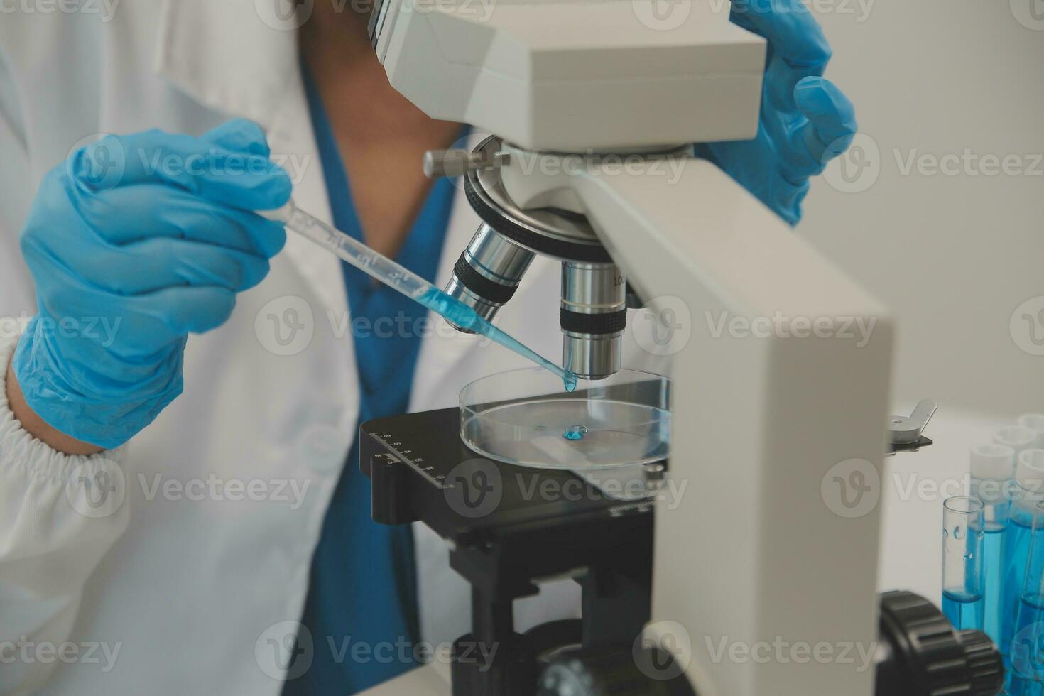 Health care researchers working in life science laboratory. Young female research scientist and senior male supervisor preparing and analyzing microscope slides in research lab. photo