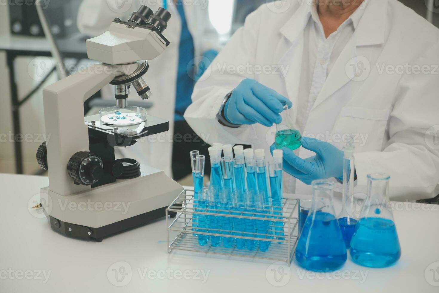 Health care researchers working in life science laboratory. Young female research scientist and senior male supervisor preparing and analyzing microscope slides in research lab. photo