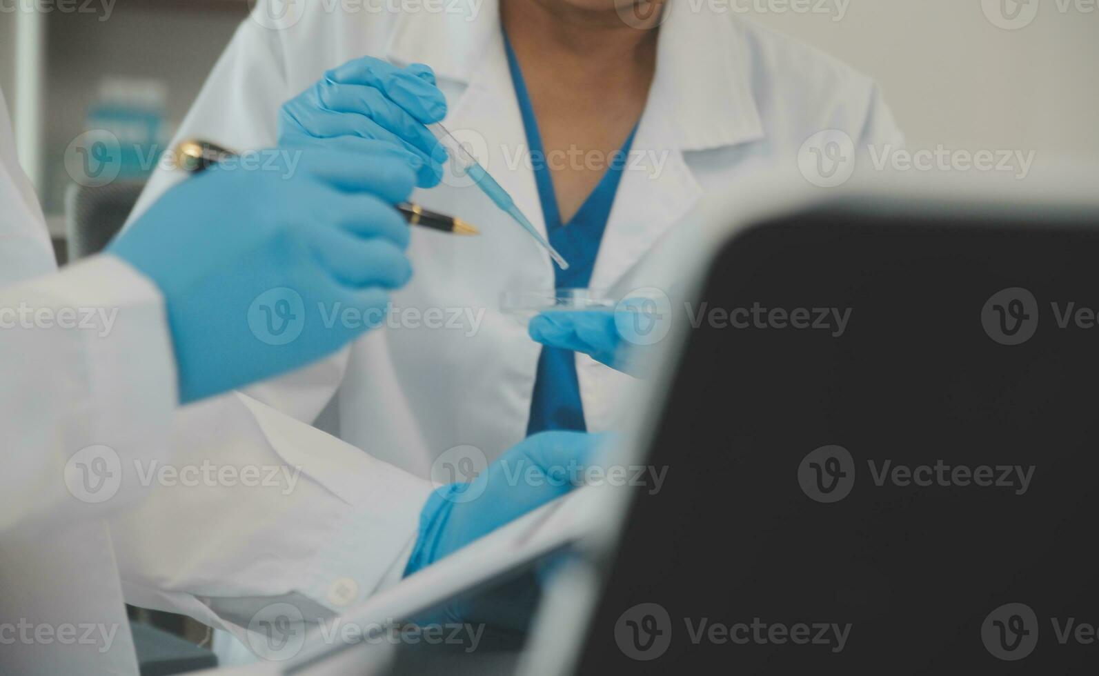 Health care researchers working in life science laboratory. Young female research scientist and senior male supervisor preparing and analyzing microscope slides in research lab. photo