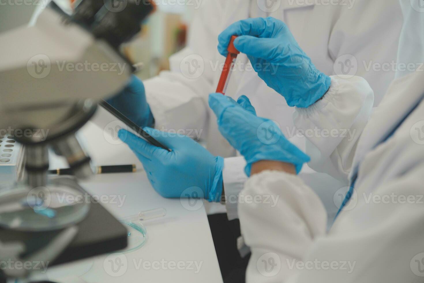 Health care researchers working in life science laboratory. Young female research scientist and senior male supervisor preparing and analyzing microscope slides in research lab. photo