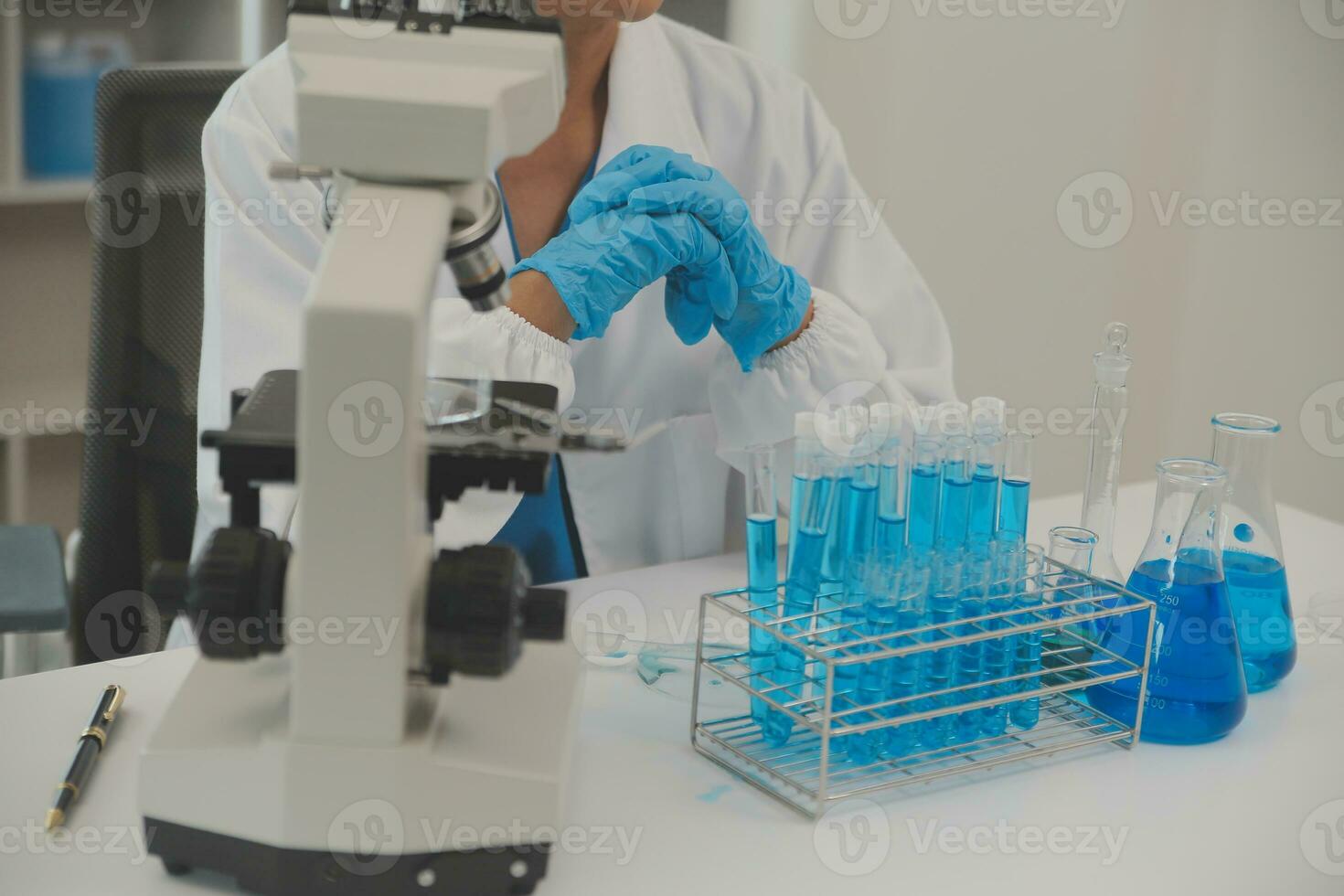 Health care researchers working in life science laboratory. Young female research scientist and senior male supervisor preparing and analyzing microscope slides in research lab. photo