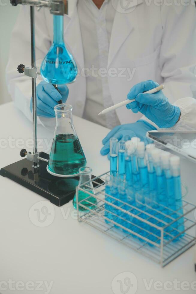 Health care researchers working in life science laboratory. Young female research scientist and senior male supervisor preparing and analyzing microscope slides in research lab. photo