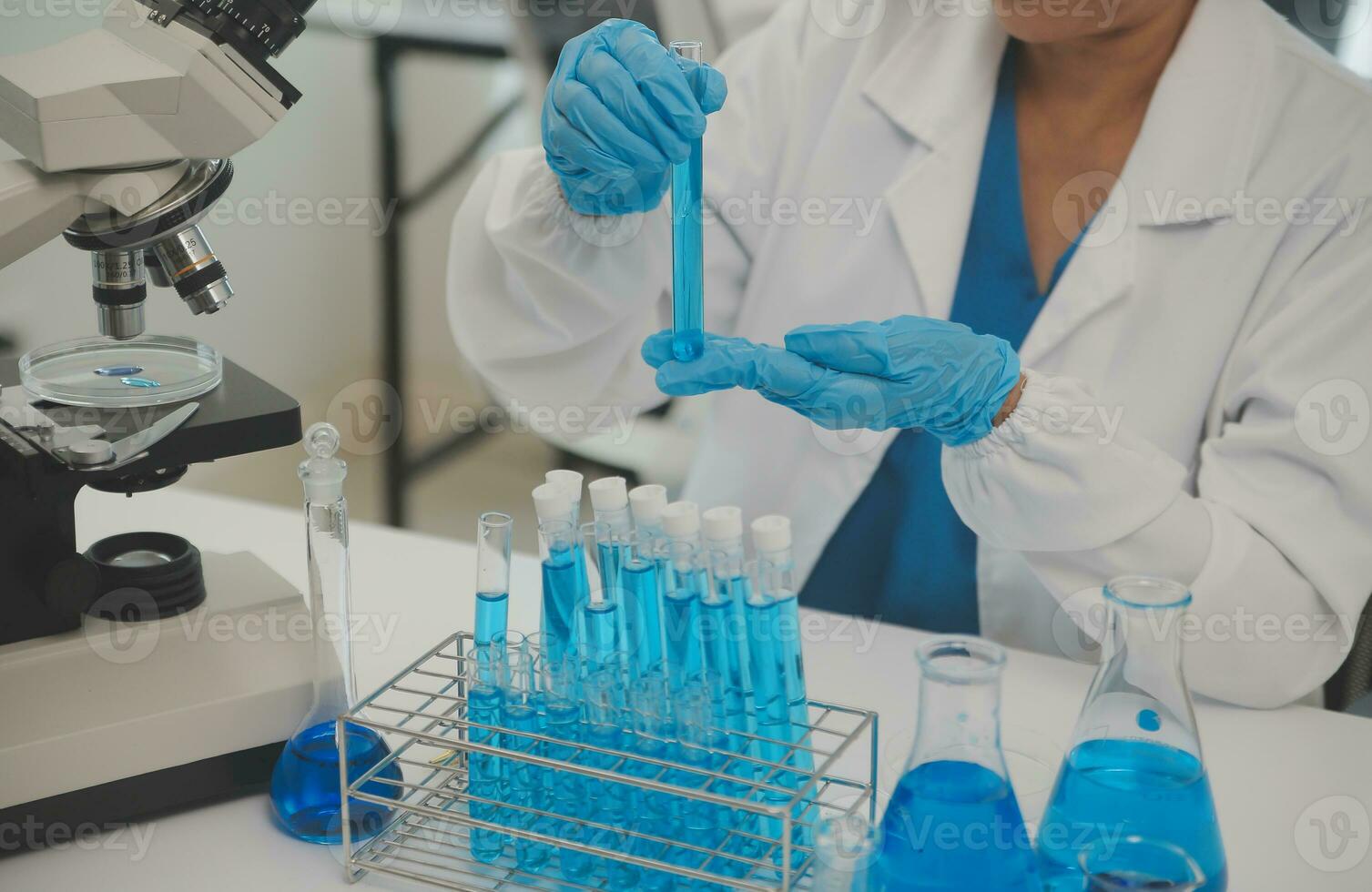Health care researchers working in life science laboratory. Young female research scientist and senior male supervisor preparing and analyzing microscope slides in research lab. photo