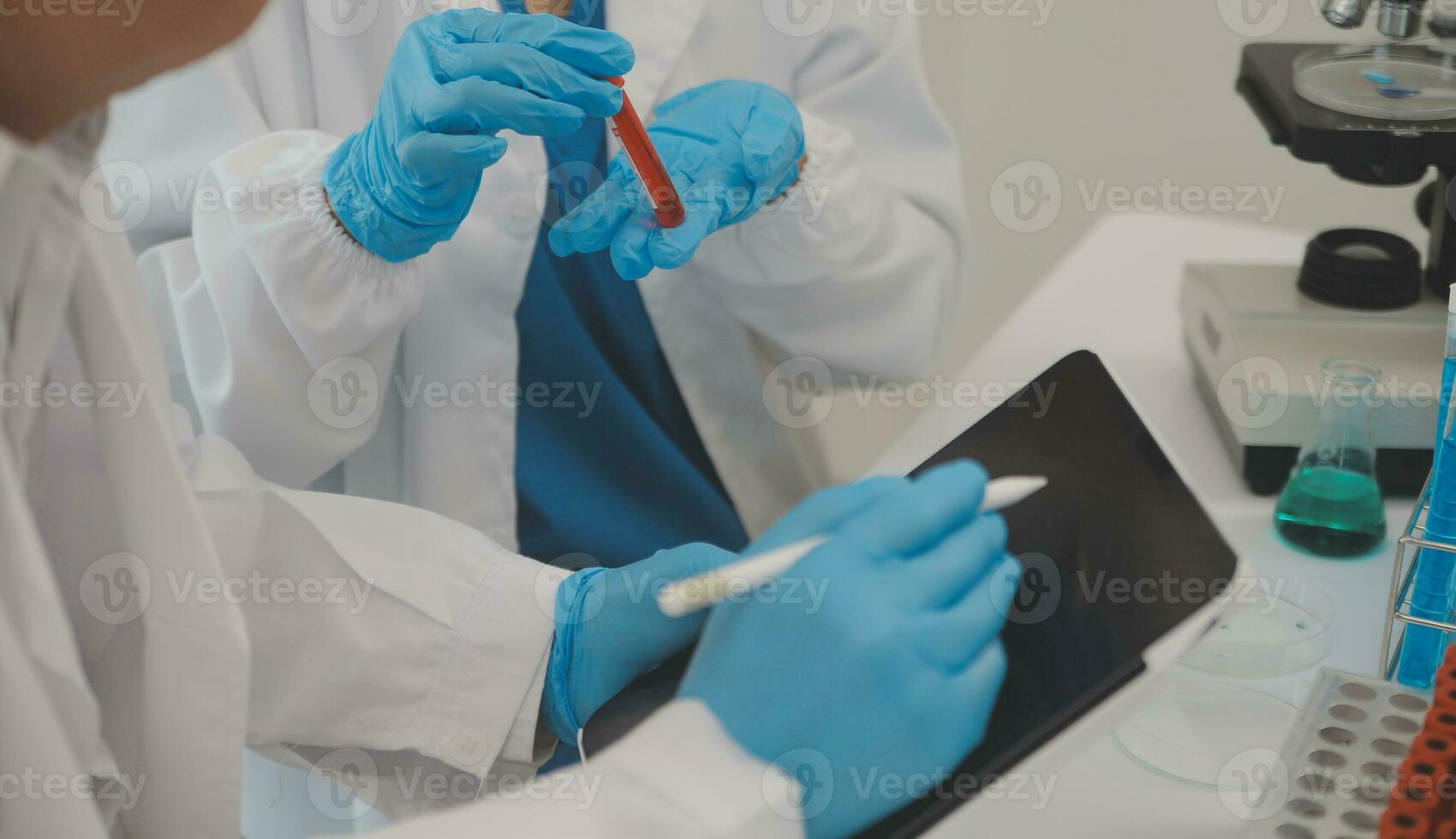 Health care researchers working in life science laboratory. Young female research scientist and senior male supervisor preparing and analyzing microscope slides in research lab. photo