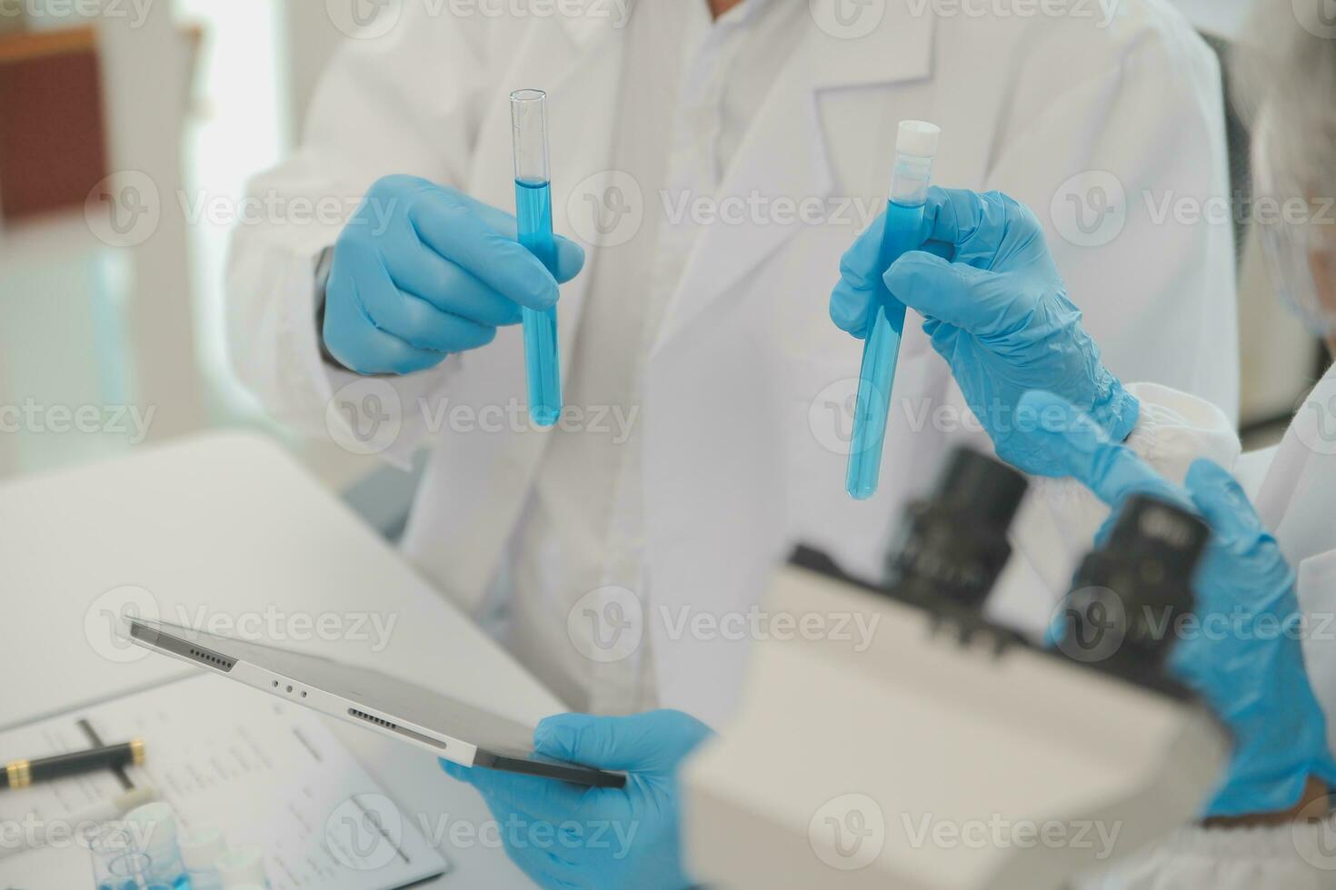 Health care researchers working in life science laboratory. Young female research scientist and senior male supervisor preparing and analyzing microscope slides in research lab. photo