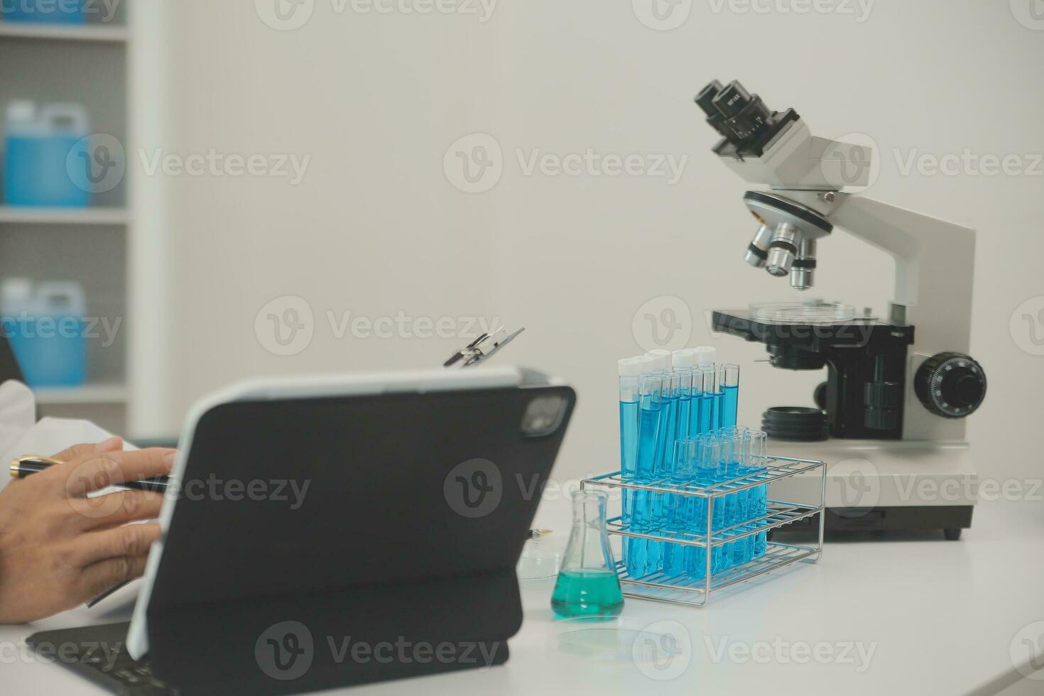 Health care researchers working in life science laboratory. Young female research scientist and senior male supervisor preparing and analyzing microscope slides in research lab. photo