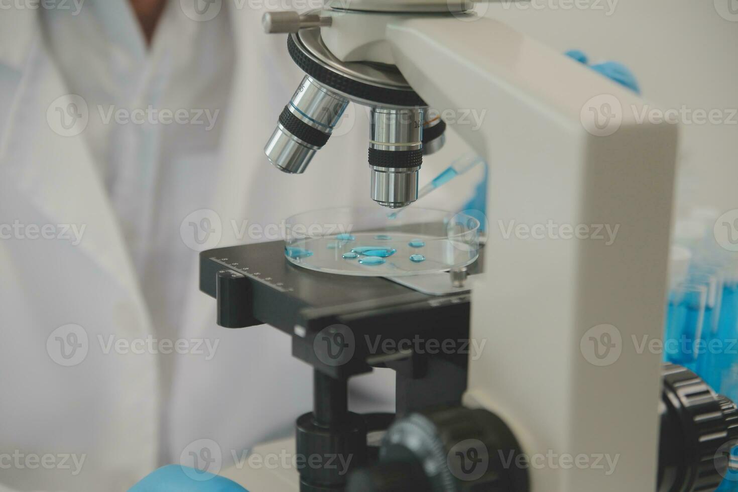Health care researchers working in life science laboratory. Young female research scientist and senior male supervisor preparing and analyzing microscope slides in research lab. photo