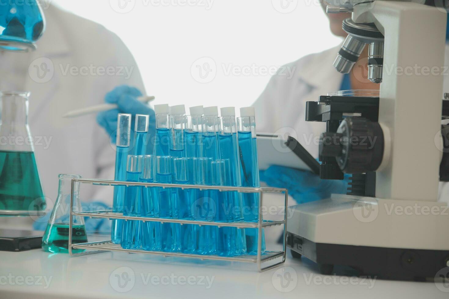 Health care researchers working in life science laboratory. Young female research scientist and senior male supervisor preparing and analyzing microscope slides in research lab. photo