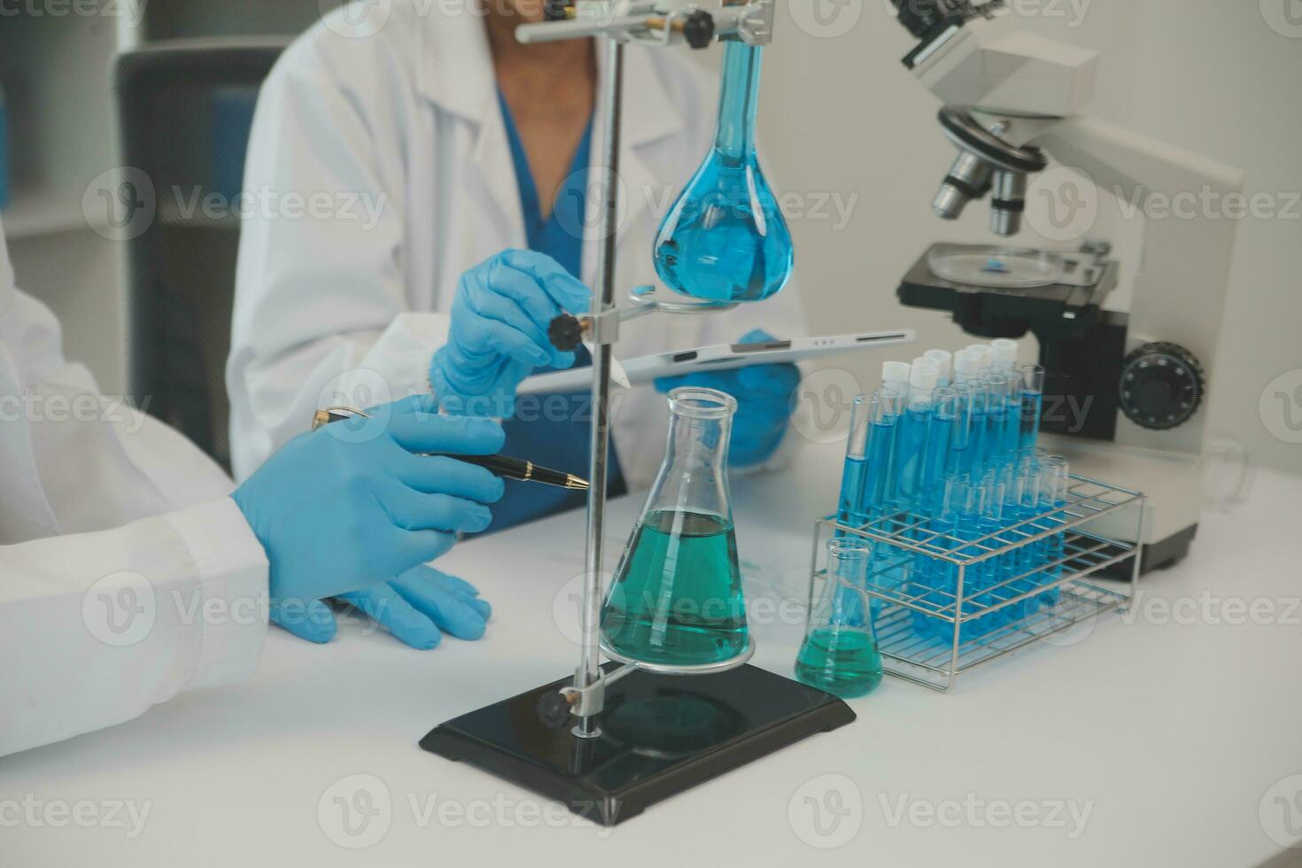 Health care researchers working in life science laboratory. Young female research scientist and senior male supervisor preparing and analyzing microscope slides in research lab. photo