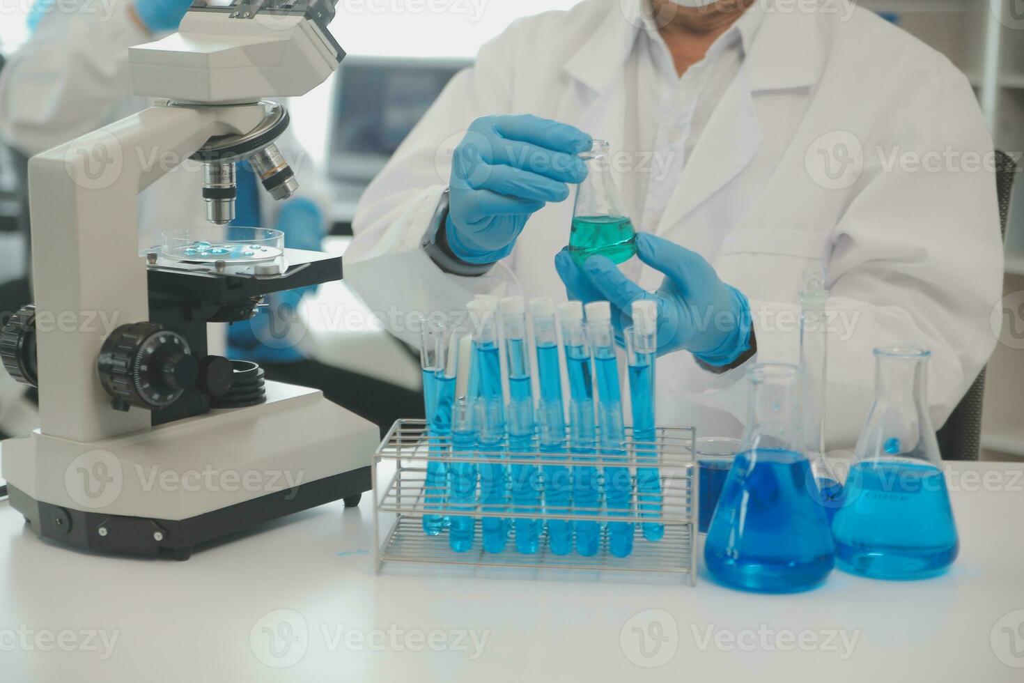 Health care researchers working in life science laboratory. Young female research scientist and senior male supervisor preparing and analyzing microscope slides in research lab. photo