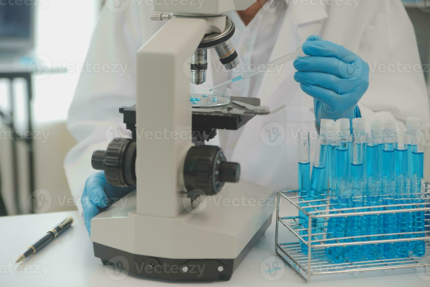 Health care researchers working in life science laboratory. Young female research scientist and senior male supervisor preparing and analyzing microscope slides in research lab. photo