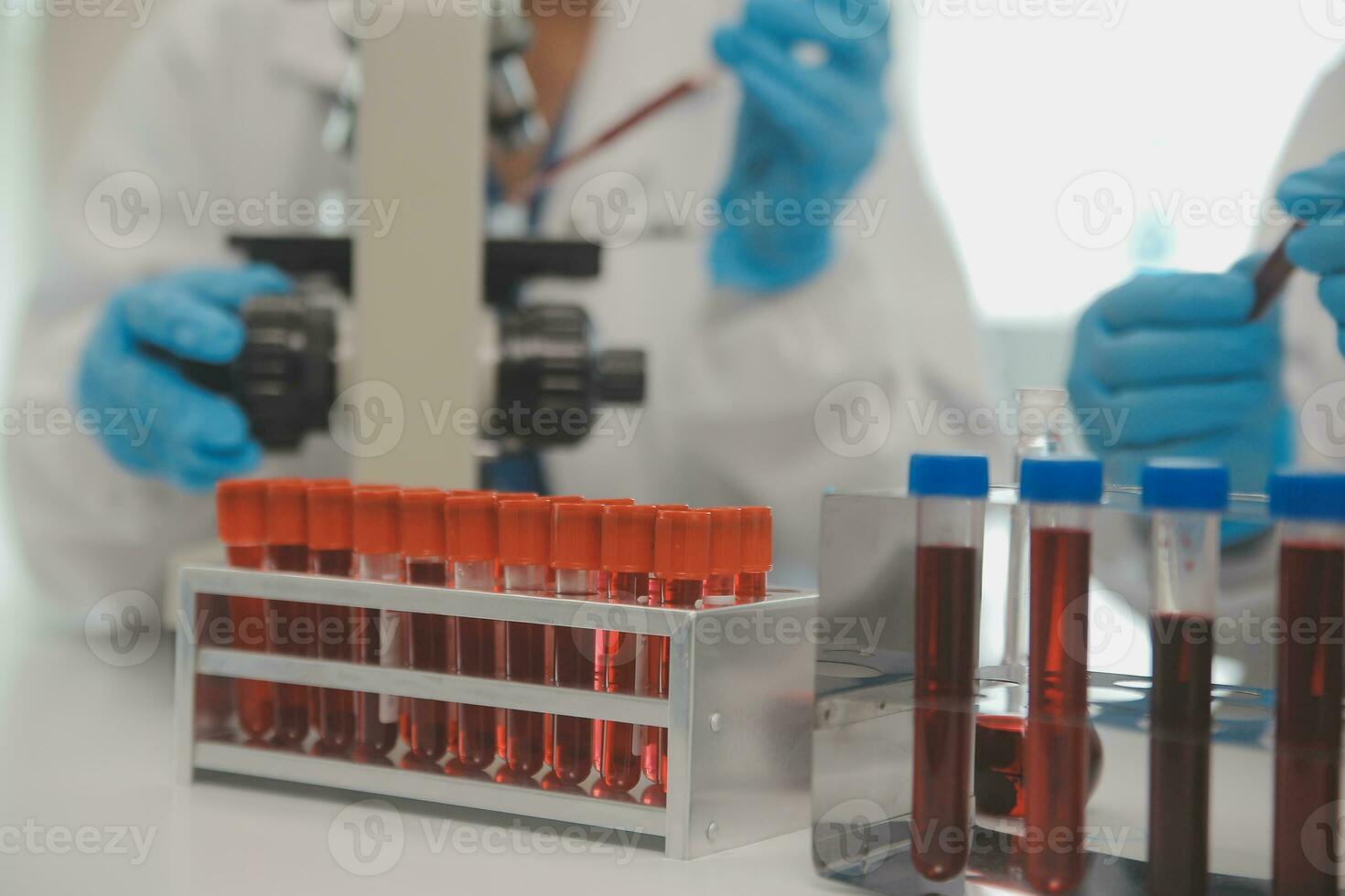 Health care researchers working in life science laboratory. Young female research scientist and senior male supervisor preparing and analyzing microscope slides in research lab. photo