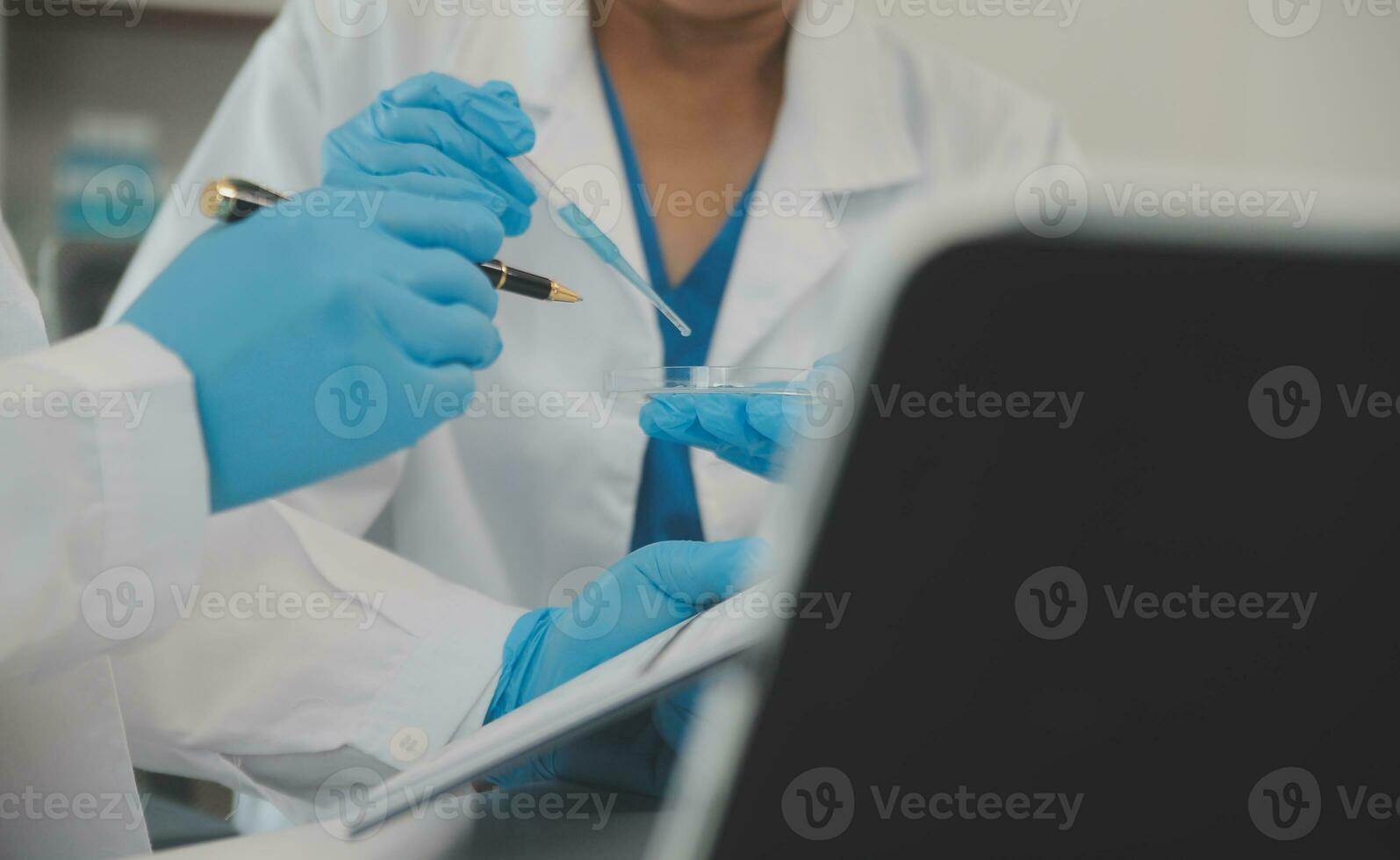 Health care researchers working in life science laboratory. Young female research scientist and senior male supervisor preparing and analyzing microscope slides in research lab. photo