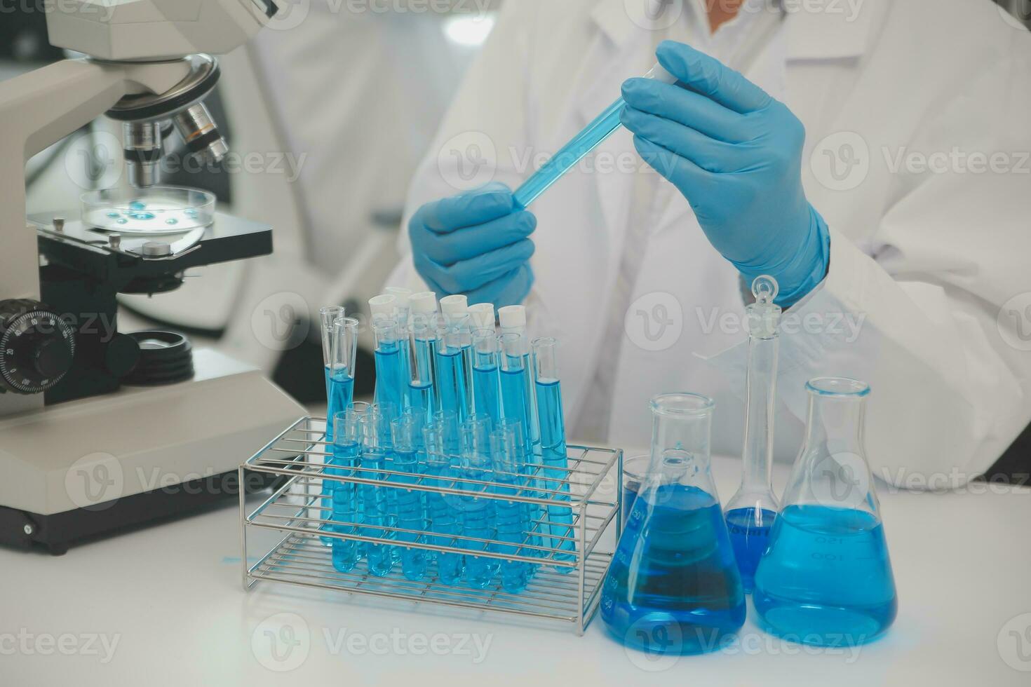 Health care researchers working in life science laboratory. Young female research scientist and senior male supervisor preparing and analyzing microscope slides in research lab. photo
