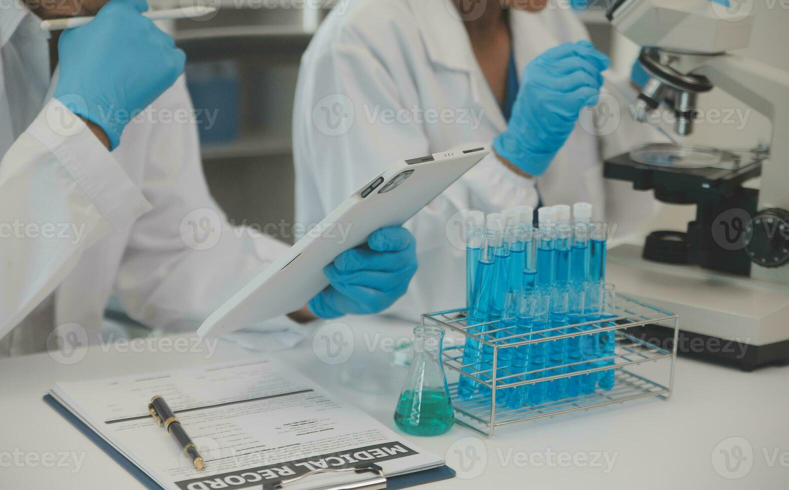 Health care researchers working in life science laboratory. Young female research scientist and senior male supervisor preparing and analyzing microscope slides in research lab. photo