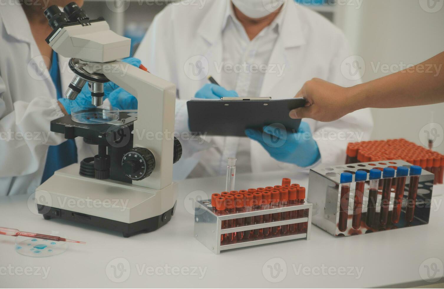 Health care researchers working in life science laboratory. Young female research scientist and senior male supervisor preparing and analyzing microscope slides in research lab. photo