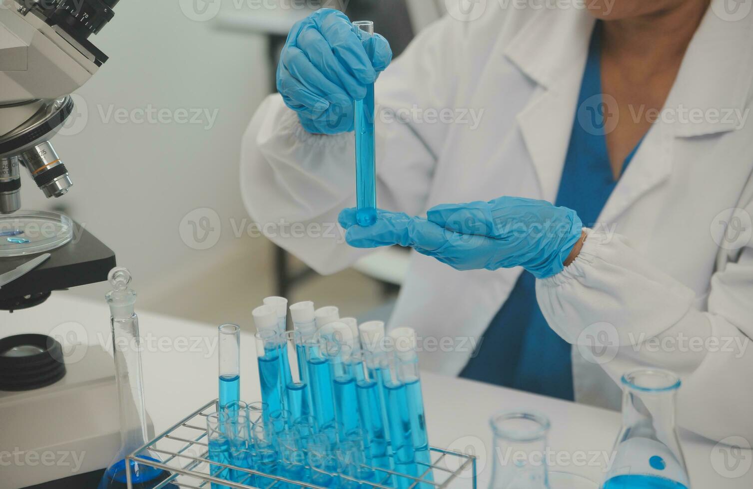 Health care researchers working in life science laboratory. Young female research scientist and senior male supervisor preparing and analyzing microscope slides in research lab. photo