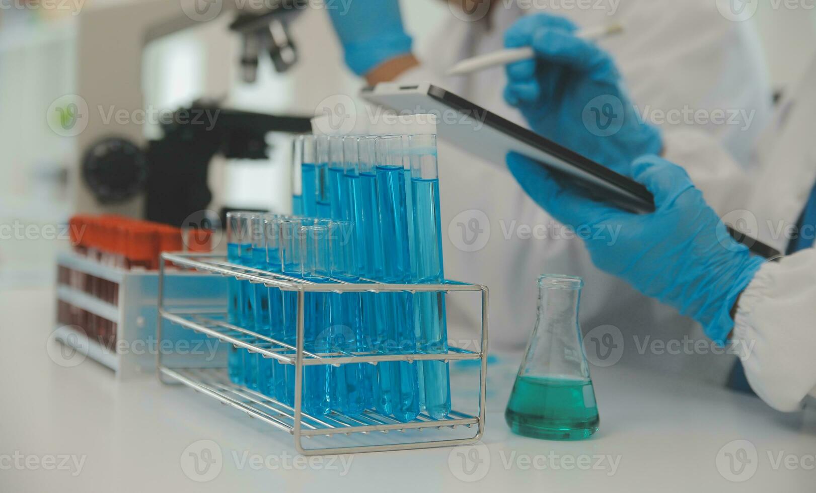 Health care researchers working in life science laboratory. Young female research scientist and senior male supervisor preparing and analyzing microscope slides in research lab. photo