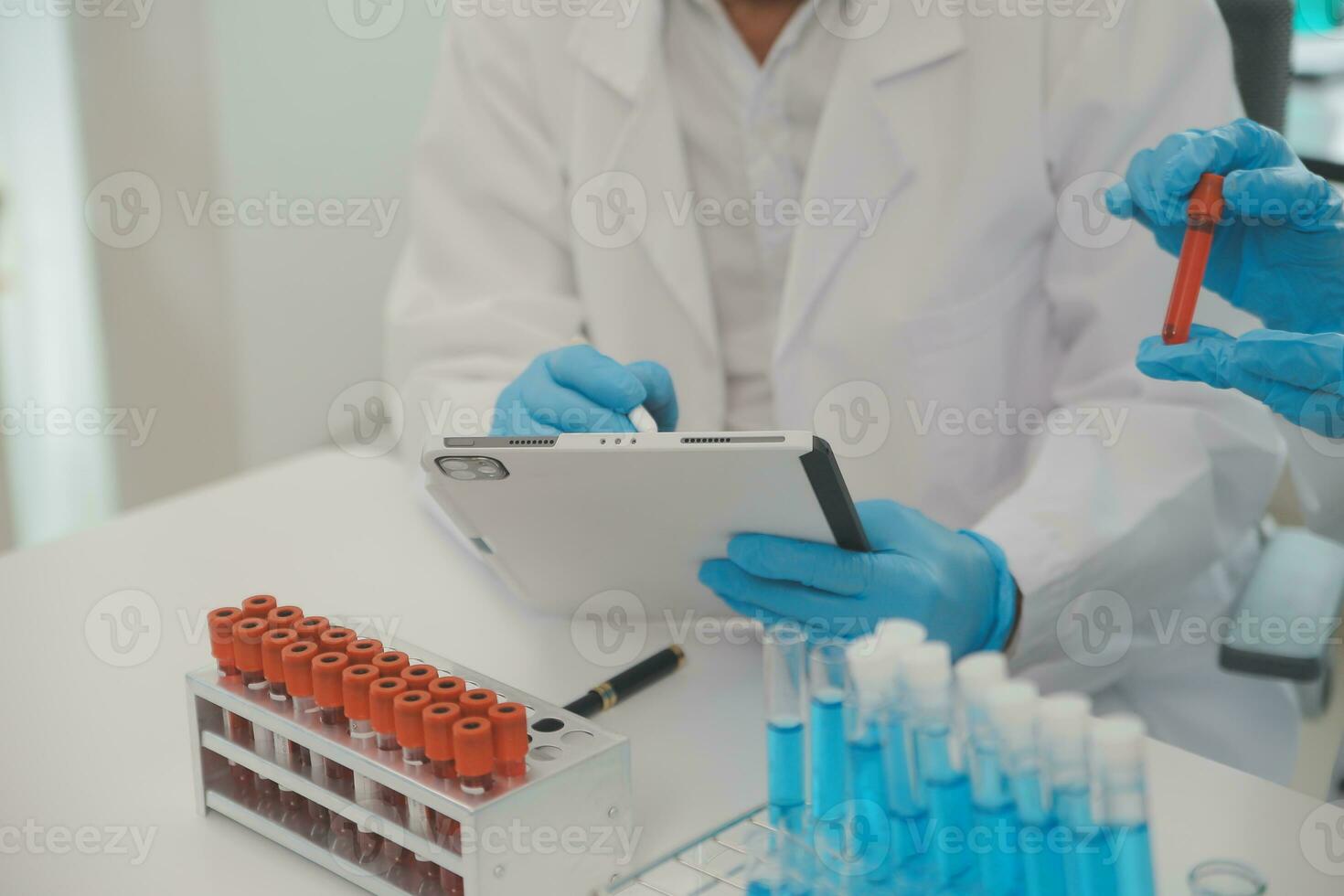 Health care researchers working in life science laboratory. Young female research scientist and senior male supervisor preparing and analyzing microscope slides in research lab. photo