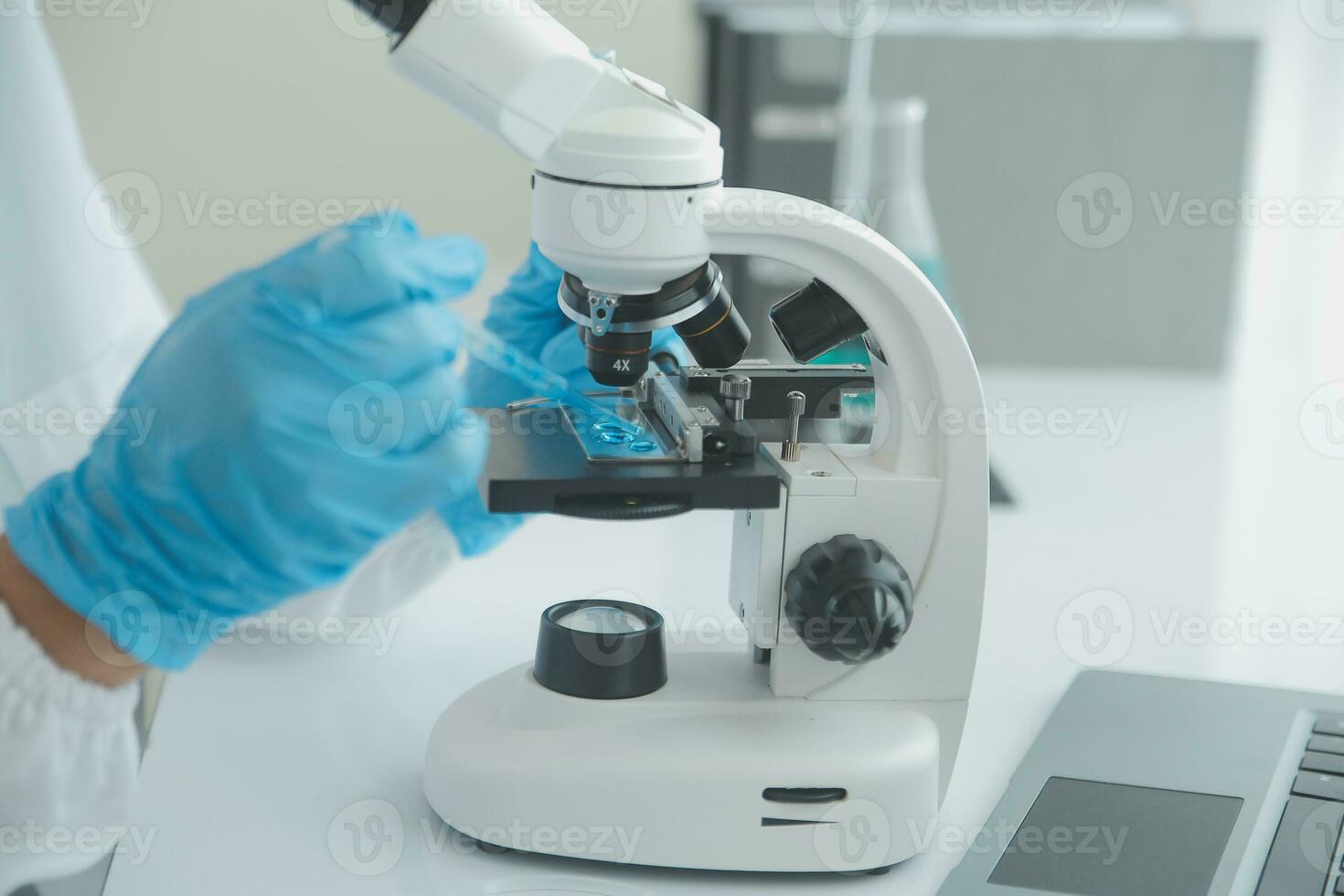 Health care researchers working in life science laboratory. Young female research scientist and senior male supervisor preparing and analyzing microscope slides in research lab. photo
