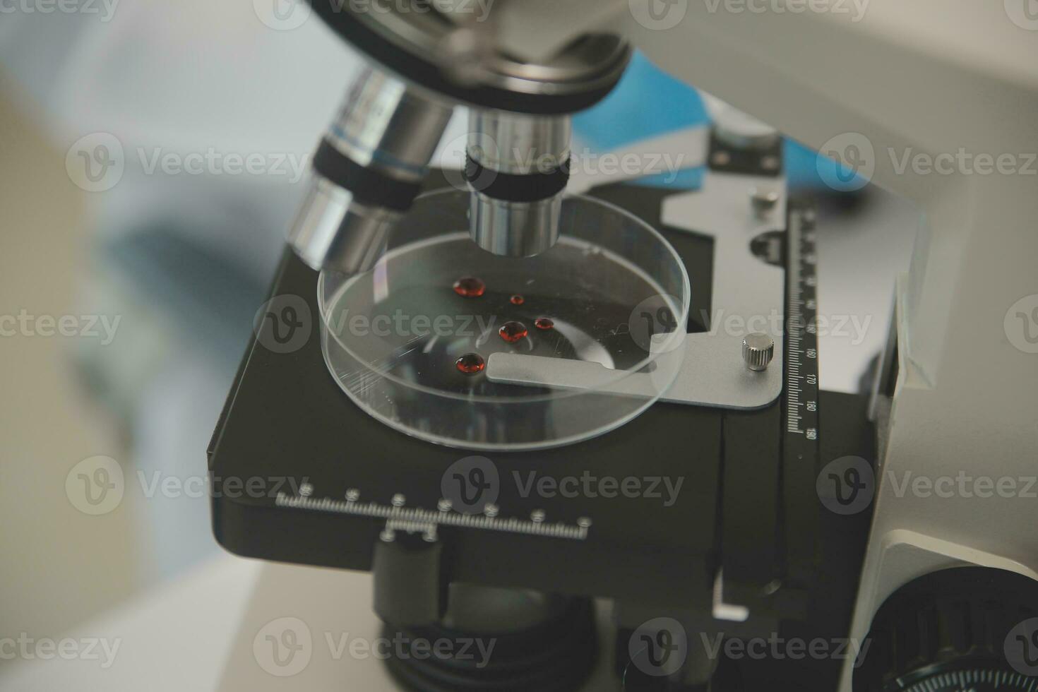 Health care researchers working in life science laboratory. Young female research scientist and senior male supervisor preparing and analyzing microscope slides in research lab. photo