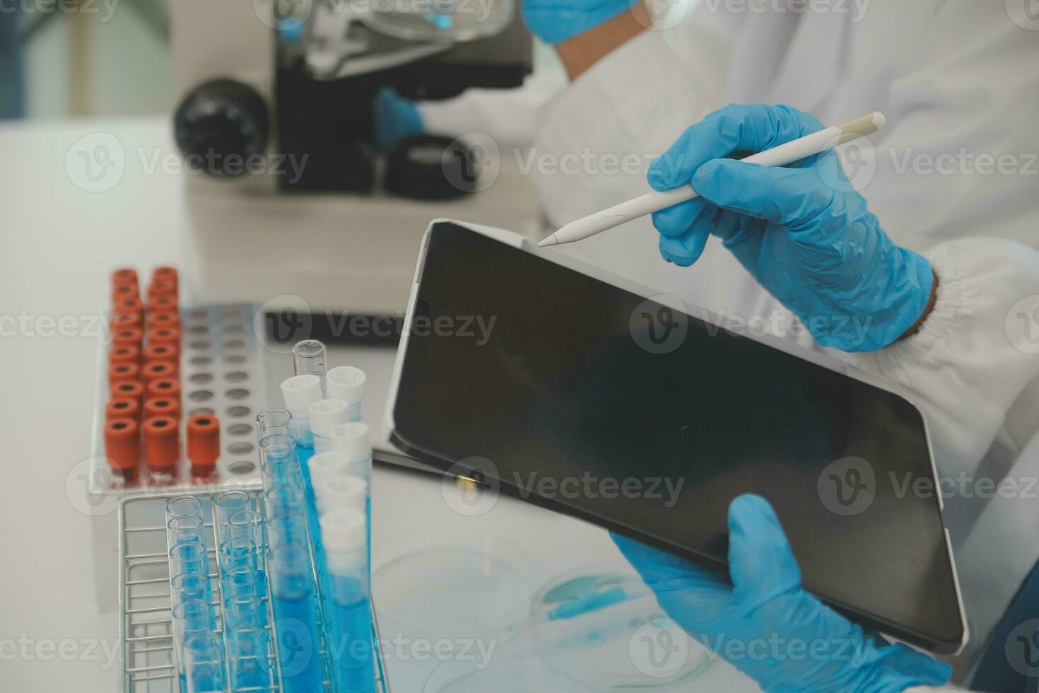 Health care researchers working in life science laboratory. Young female research scientist and senior male supervisor preparing and analyzing microscope slides in research lab. photo