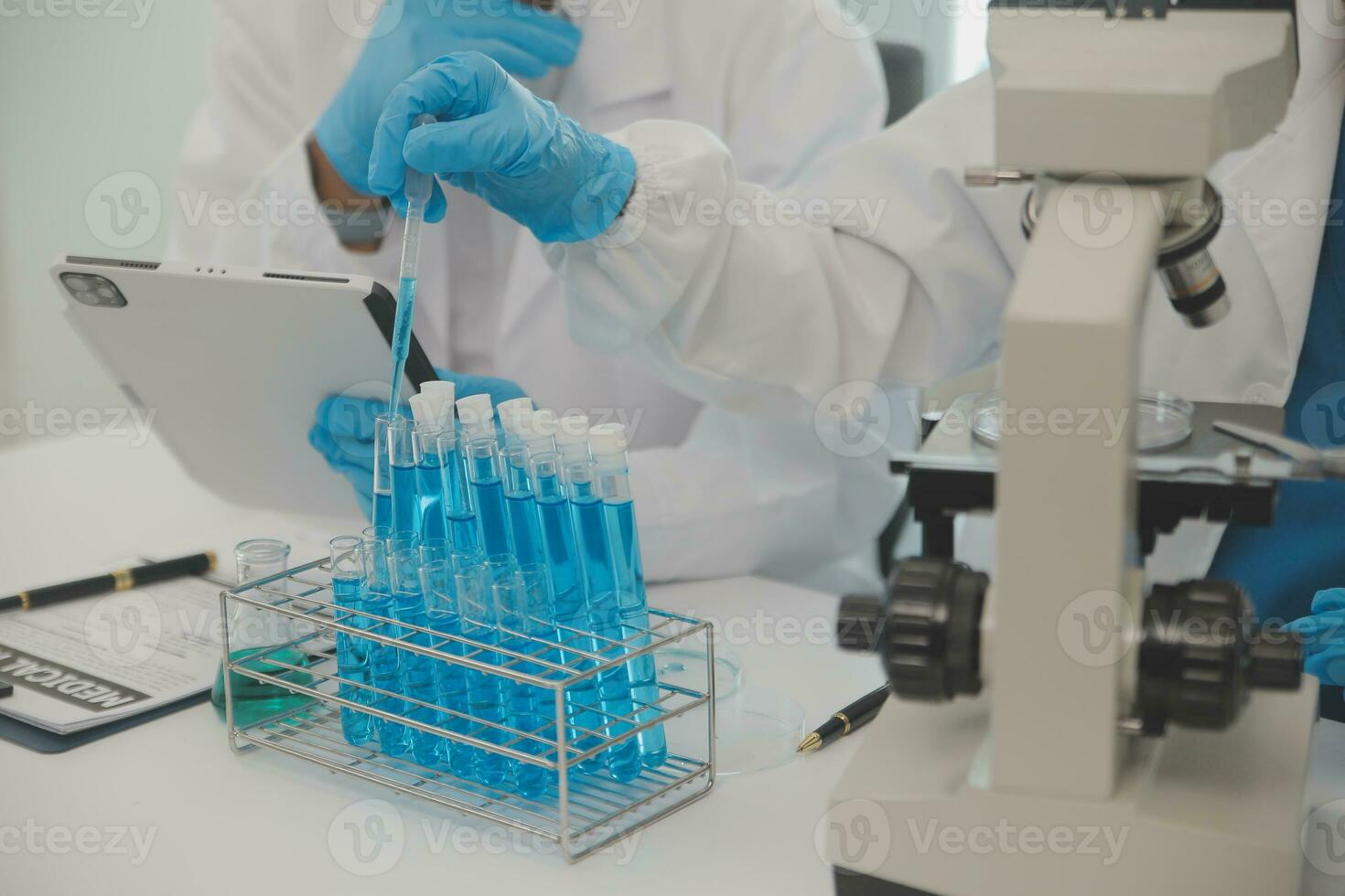 Health care researchers working in life science laboratory. Young female research scientist and senior male supervisor preparing and analyzing microscope slides in research lab. photo