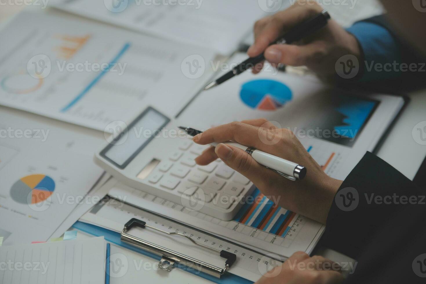 Financial analysts analyze business financial reports on a digital tablet planning investment project during a discussion at a meeting of corporate showing the results of their successful teamwork. photo