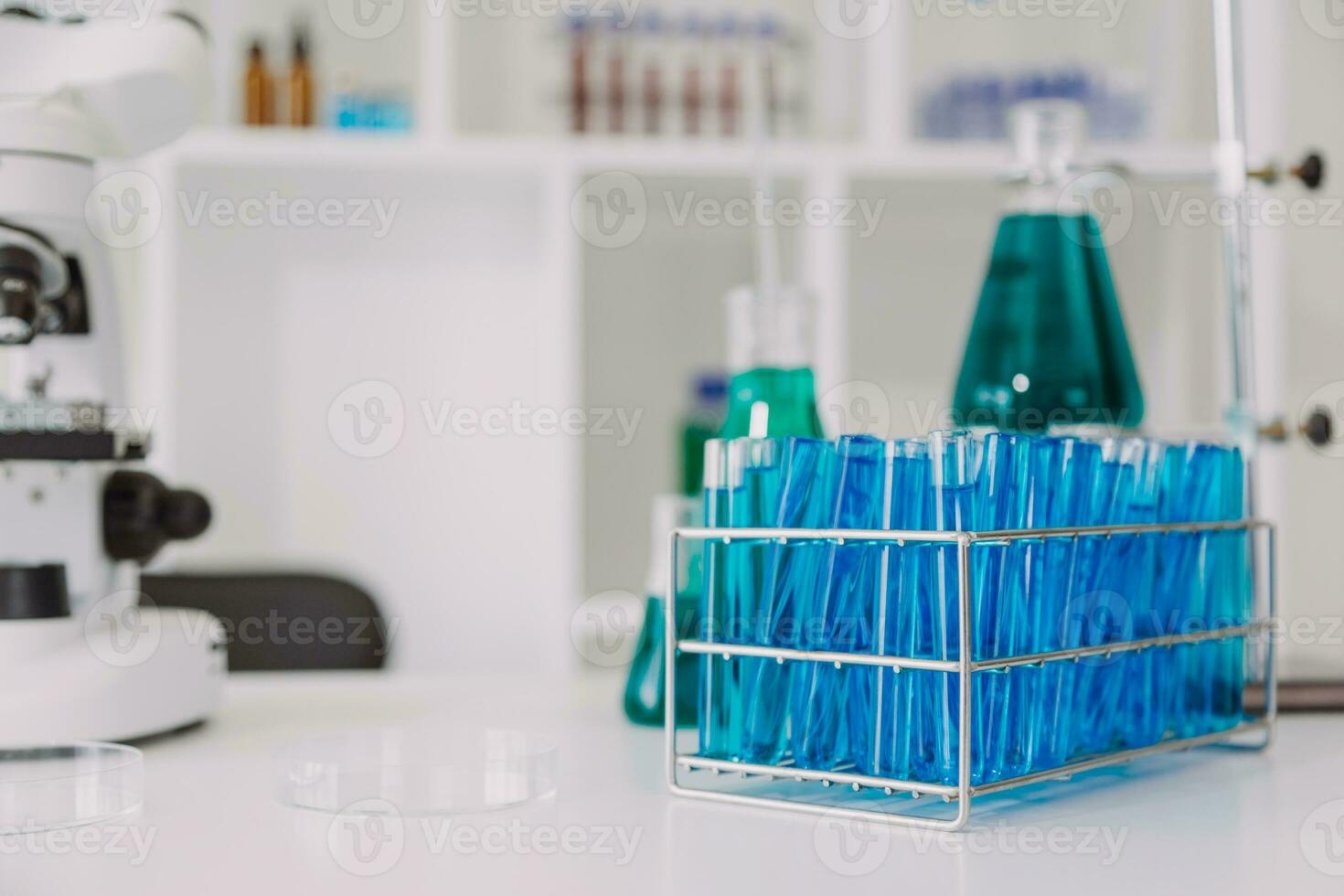 Young scientists conducting research investigations in a medical laboratory, a researcher in the foreground is using a microscope photo