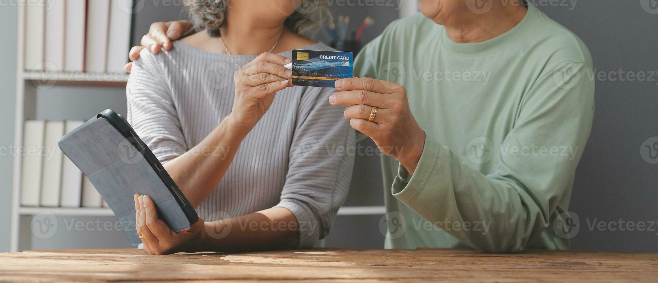 Close up mature man holding plastic credit card, senior couple family paying online, using laptop, satisfied older customers making secure internet payment, shopping, browsing banking service photo