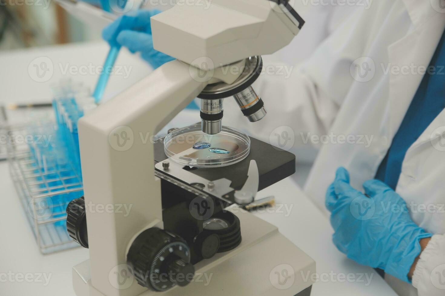 Health care researchers working in life science laboratory. Young female research scientist and senior male supervisor preparing and analyzing microscope slides in research lab. photo
