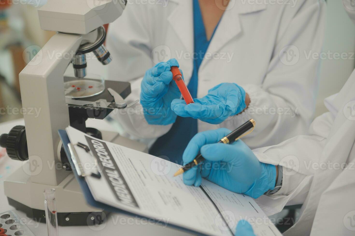 Health care researchers working in life science laboratory. Young female research scientist and senior male supervisor preparing and analyzing microscope slides in research lab. photo
